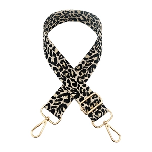 Adjustable leopard print bag strap with golden metal hooks on a white background