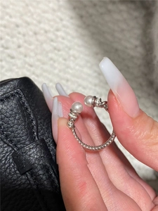 Detail of silver cable ring with white pearls and zircons worn on finger close-up