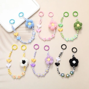 Detalle de correas de cuentas hechas a mano con flores de punto y dijes de corazones