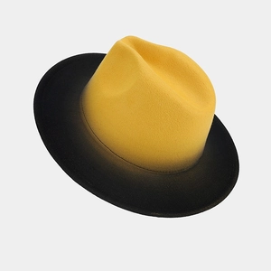 Detail view of stylish yellow-to-black gradient fedora hat with wool texture and flat brim
