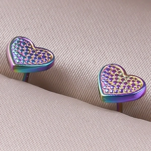 Macro view of rainbow heart studs with textured finish in stainless steel