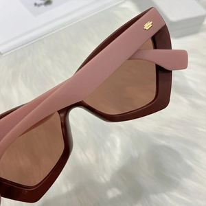 Close-up of wine red frames and pink temples with gold rectangle detail on sunglasses