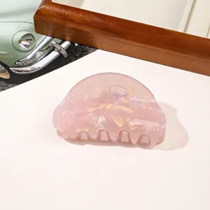 Close-up of a pink marble texture hair claw clip with a glossy iridescent finish