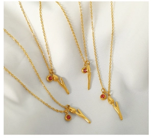 Detail of 18k gold tulip pendant with red rhinestone on a polished chain necklace