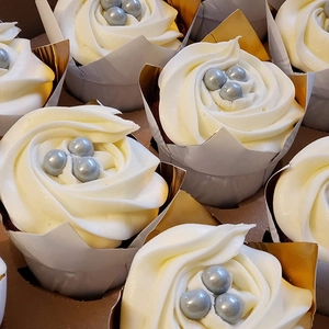 Macro shot of tulip cupcake liners with white buttercream swirls and silver sugar pearls