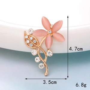 Macro view of pink opal flower brooch with crystal inlay on a gold-tone base