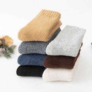 Close-up of neatly stacked wool socks in various neutral colors for autumn and winter