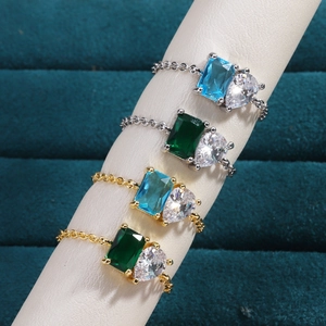 Detail of adjustable chain rings with emerald and aquamarine zircon on display