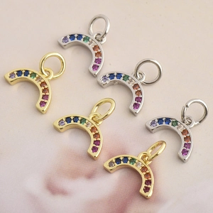 Macro shot of U-shaped rainbow pendants with multi-colored cubic zirconia in gold and silver