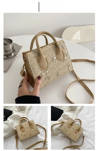 Close-up of khaki straw handbag featuring floral embroidery and round leather handle