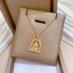 Vue macro d'un collier en titane doré avec pendentif couronne sur fond de soie