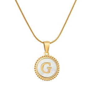 Dettaglio del ciondolo lettera G in oro 18K con inserto in madreperla su collana tonda