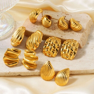 Detailed set of five pairs of vintage style gold geometric earrings on stone and silk