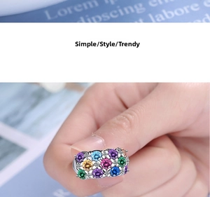 Detailed close-up of a silver band ring pavé-set with vibrant multi-colored gemstones
