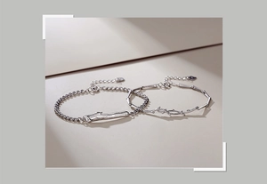 Detailed view of sterling silver couple bracelets with feather and thorn branch motifs