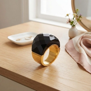 Close-up of a 18k gold plated chunky ring featuring a faceted black crystal stone