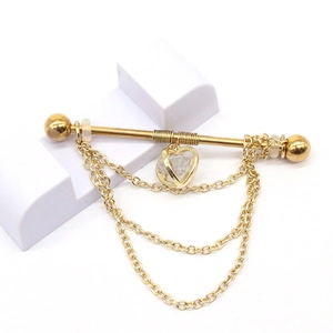 Detail of golden industrial piercing with triple chains and heart zircon pendant
