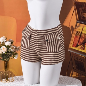 Detail van gestreepte gebreide shorts met dubbele zakken en gouden sierknopen