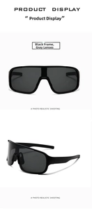Detail of sports sunglasses featuring black frame and gray lens with aerodynamic design