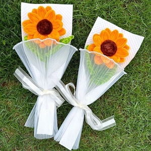 Two handmade pipe cleaner sunflower bouquets wrapped in tulle on green grass