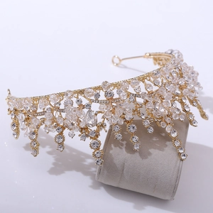 Detail of baroque bridal tiara with gold frame and crystals on velvet stand
