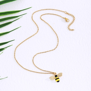 Macro detail of golden bee pendant with enamel finish and shimmering crystal rhinestones