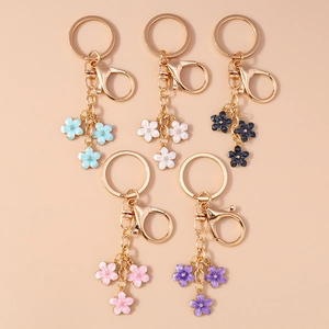 Five gold-plated cherry blossom keychains in blue, white, black, pink and purple