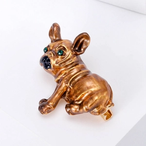 Detail of a vintage bronze bulldog brooch featuring sparkling green rhinestone eyes