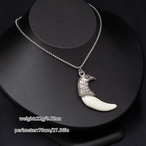 Detailed view of wolf tooth pendant necklace on a black mannequin with size specifications