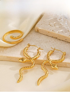 Detail shot of golden snake-shaped ring and earrings set with scale texture on stone base