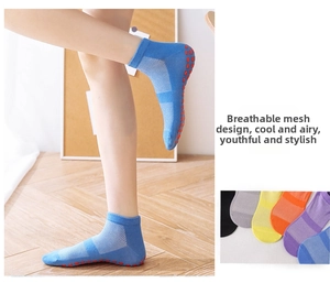 Detail of breathable mesh design and red non-slip dots on sky blue yoga grip socks