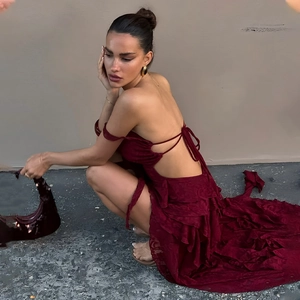 Side view of dark red backless lace dress showing pleated hem and irregular cut detailing