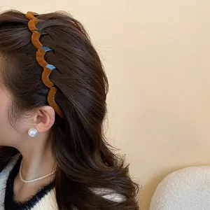 Brown velvet wavy headband with elegant pearl jewelry on a model in autumn style