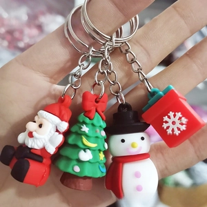 Close-up of four Christmas themed keychains featuring Santa, Snowman, and Tree