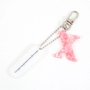 Pink letter K keychain with French quote tag on a silver metal ring accessory