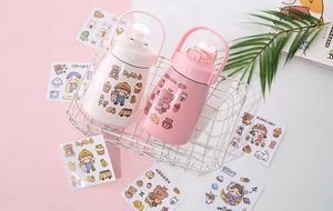 Close-up of cute cartoon PVC stickers applied on pink and beige water bottles