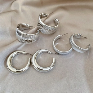 Detailed view of three pairs of silver hoop earrings with ribbed and smooth textures