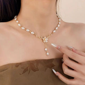 Détail du pendentif fleur avec pampilles de perles sur un collier vintage doré