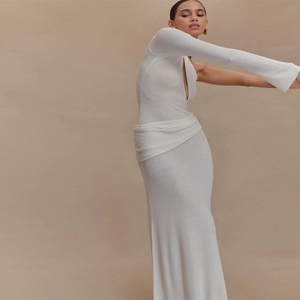Détail de la maille blanche et de la manche asymétrique ajourée de la robe ajustée