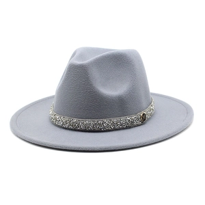 Detailed close-up of grey wool fedora hat with sparkling rhinestone band and M metal logo