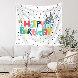 Detail view of Bohemian birthday tapestry hanging above a modern sofa in a living room