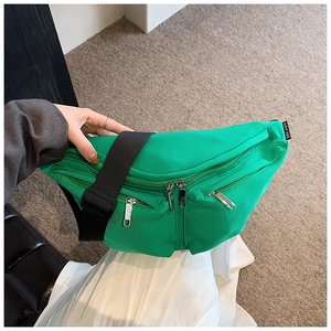 Detail view of emerald green nylon crossbody chest bag with adjustable black strap