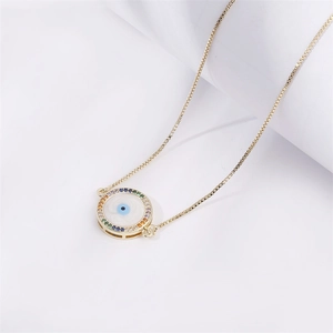 Golden box chain necklace featuring a colorful zircon evil eye pendant on a white background