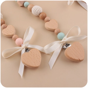 Handmade wooden pacifier clip with silicone beads and a crochet bow for infants