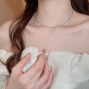 Close-up of silver stainless steel necklace with sparkling zircon stones on female neck