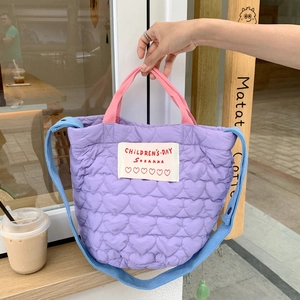 Détail du matelassage en cœur du sac fourre-tout mauve avec bandoulières colorées