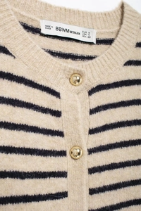 Macro detail of striped knit cardigan collar with golden buttons and brand label
