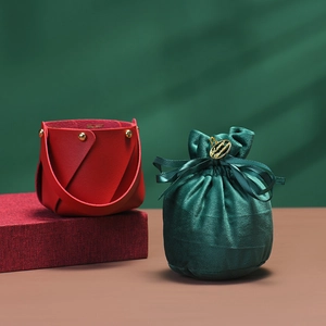 Detail of red leather gift basket and green velvet pouch with Merry Christmas tag