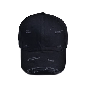 Retro distressed black baseball cap with ripped brim and streetwear aesthetic