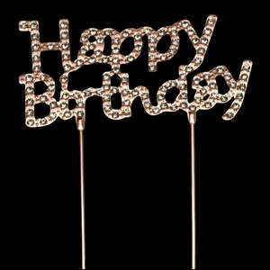 Close-up of rose gold Happy Birthday cake topper with rhinestones on a black background